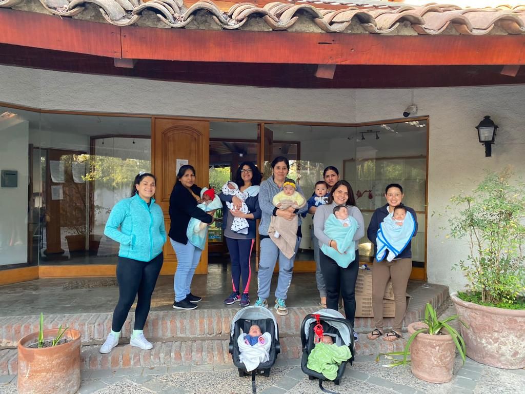 Un grupo de mamás reunidas en la entrada de la casa, con sus hijos.